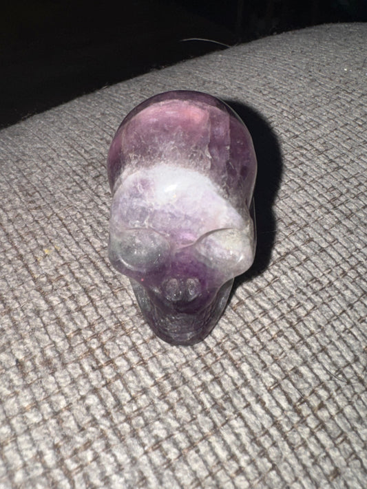Purple crystal skull on a textured surface