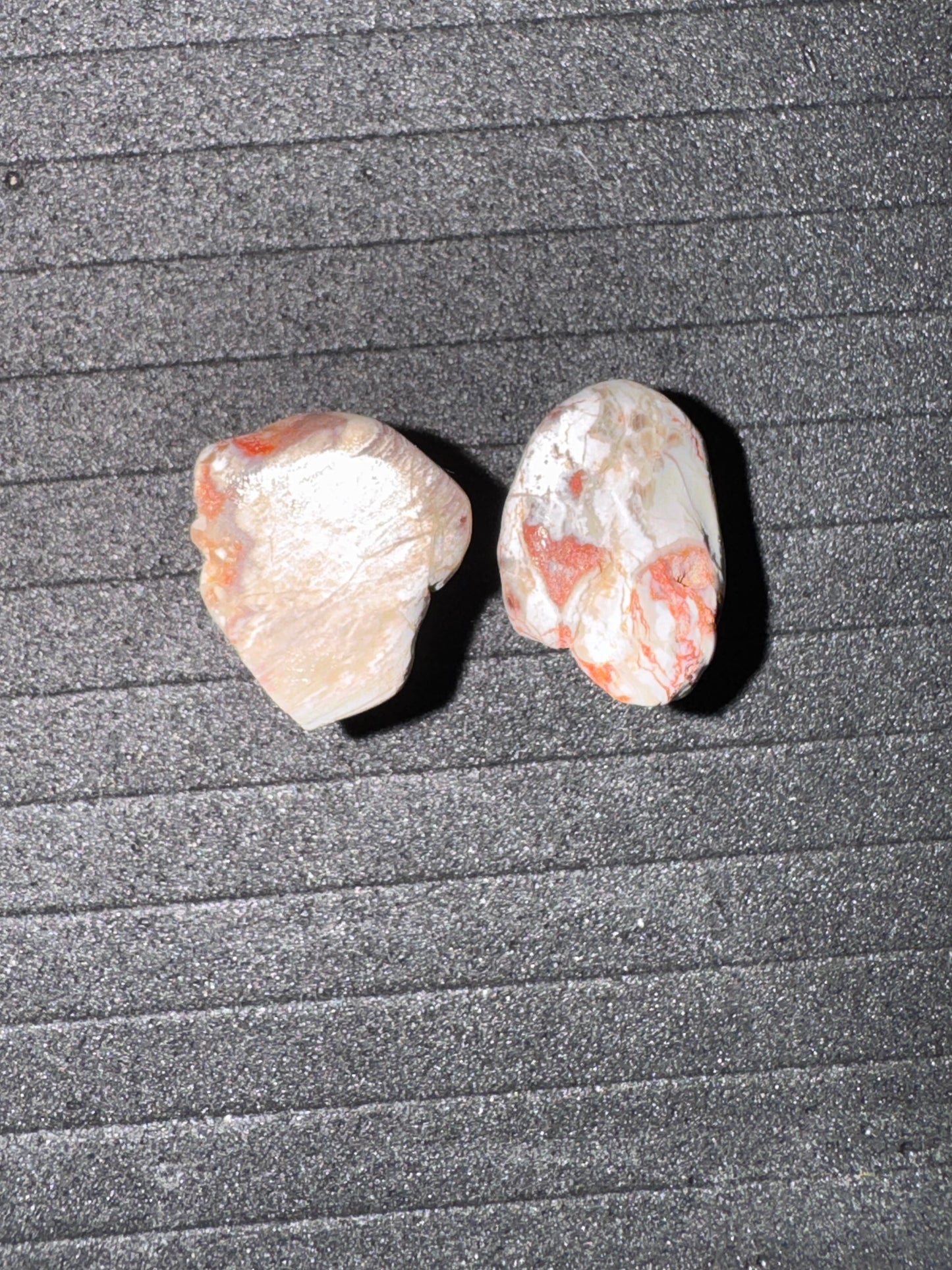 Two small stones on a textured gray surface