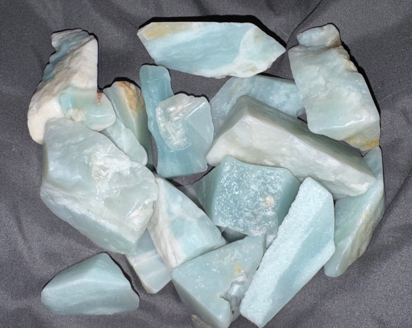 Collection of light blue-green crystals on a dark gray background