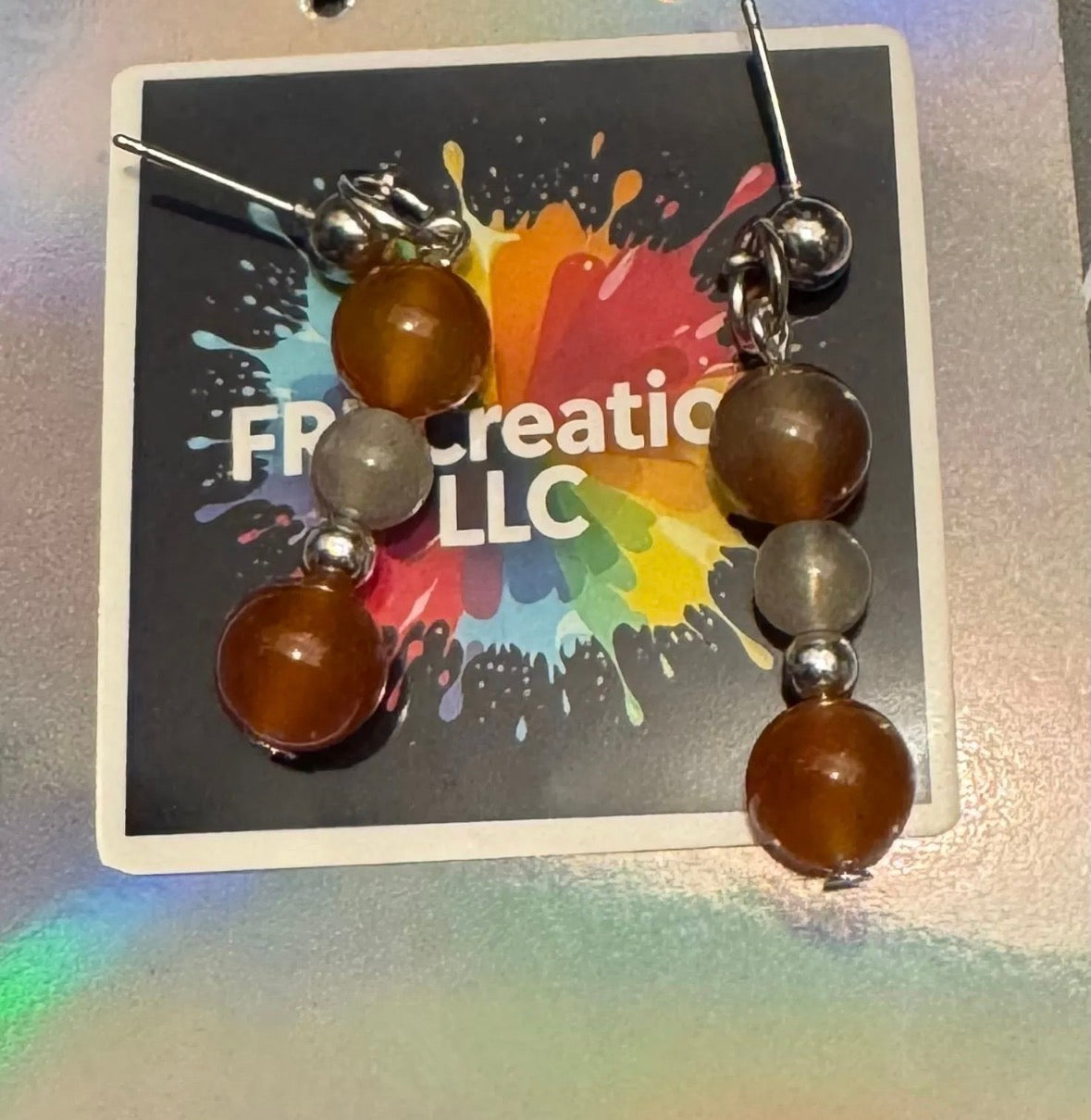 Pair of earrings with Labradorite and Carnelian beads on a colorful branded card.
