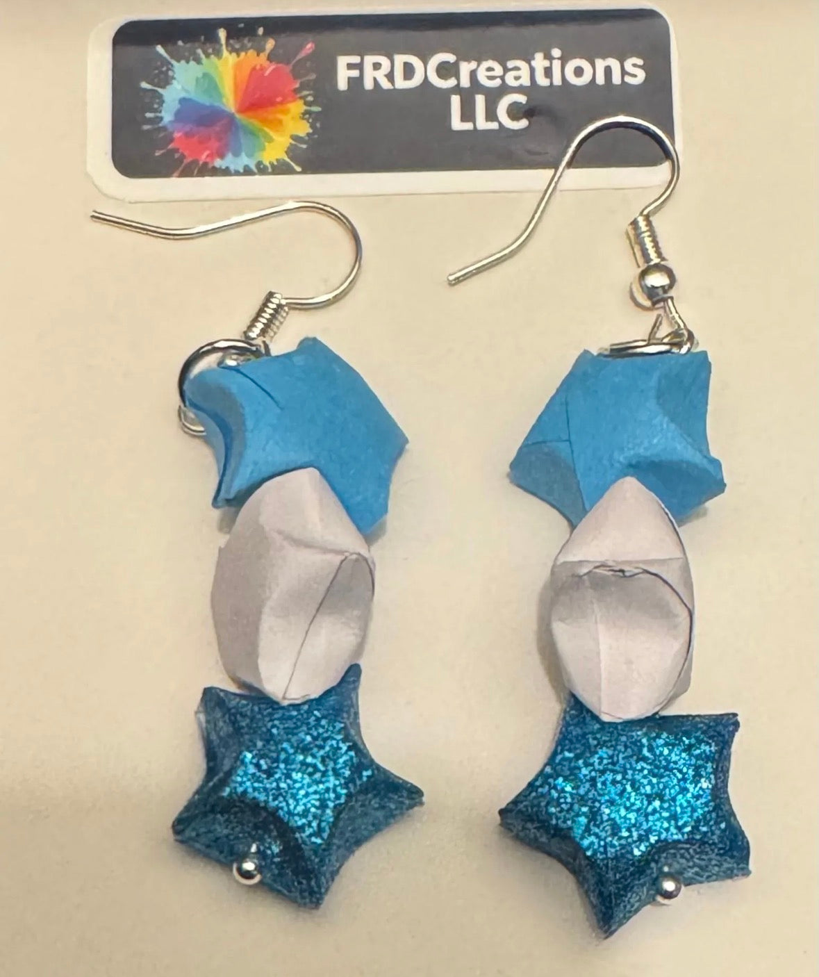 Pair of star-shaped earrings with blue, white and silver design