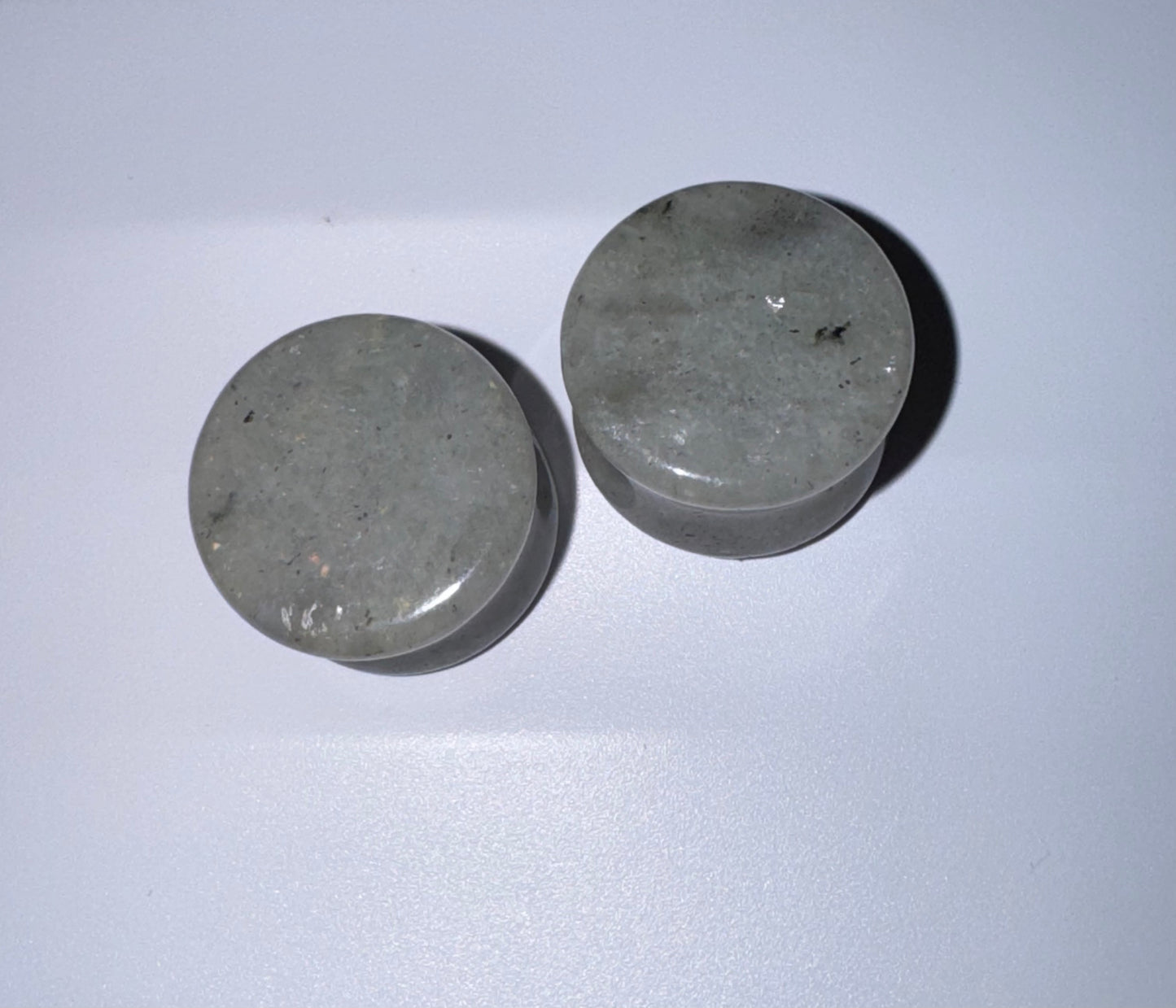 Two labradorite ear gauges on a white background