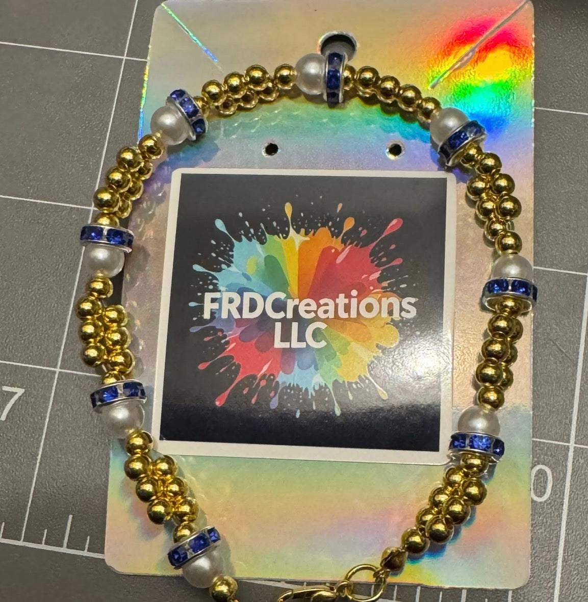 Bracelet with gold, pearl, and blue beads on a card