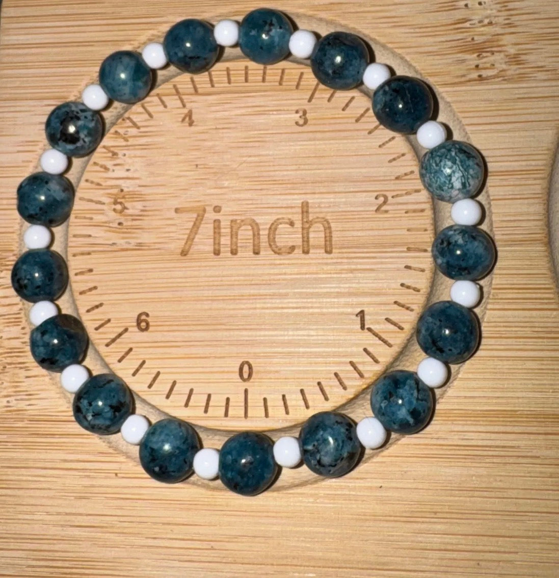 Bracelet with blue and white beads on a wooden ruler