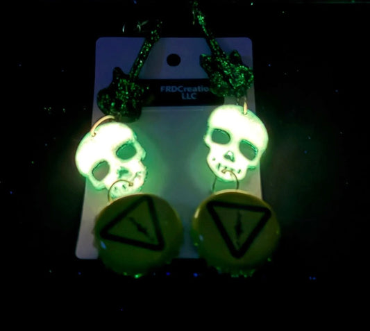 Glowing skull-shaped earrings on a dark background w