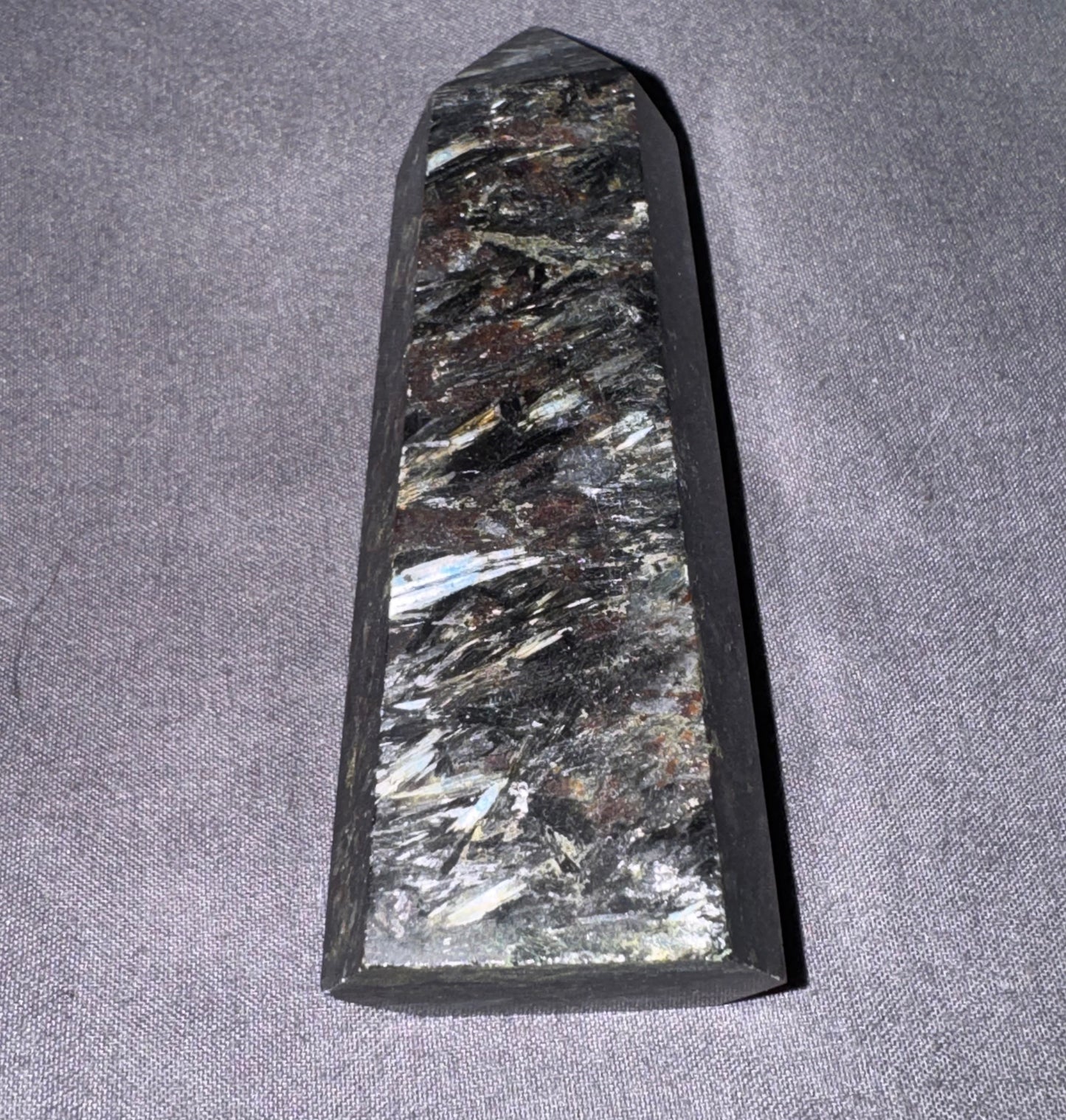 Decorative stone with crystal-like inclusions on a gray fabric background