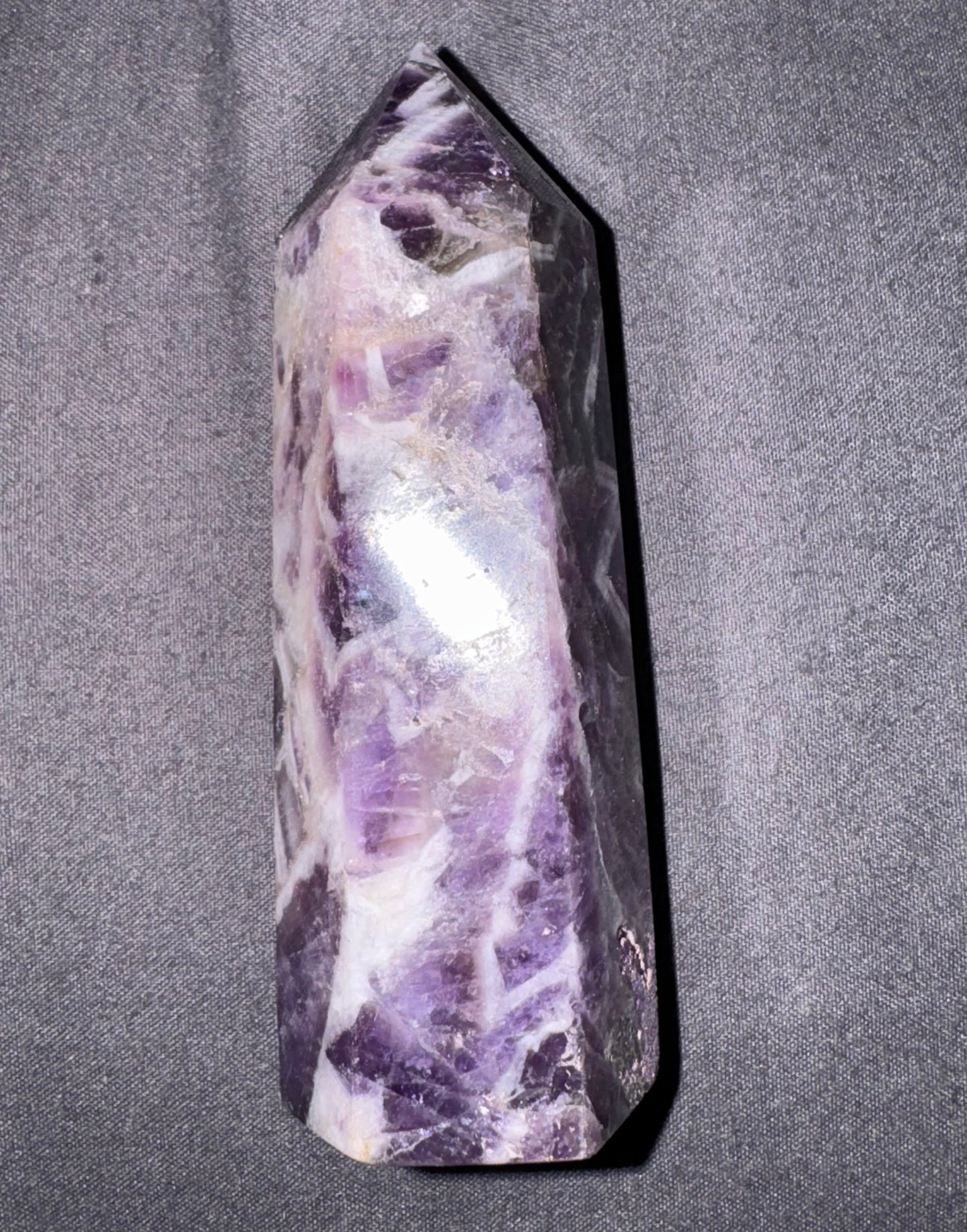 Amethyst crystal on a gray fabric background