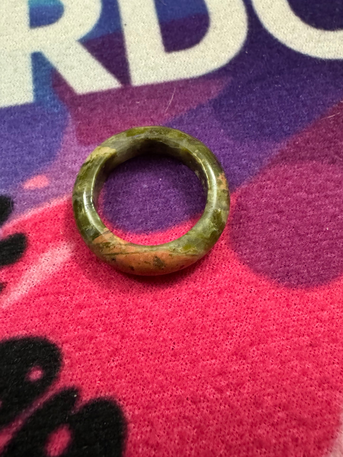 Unakite ring on a colorful fabric background