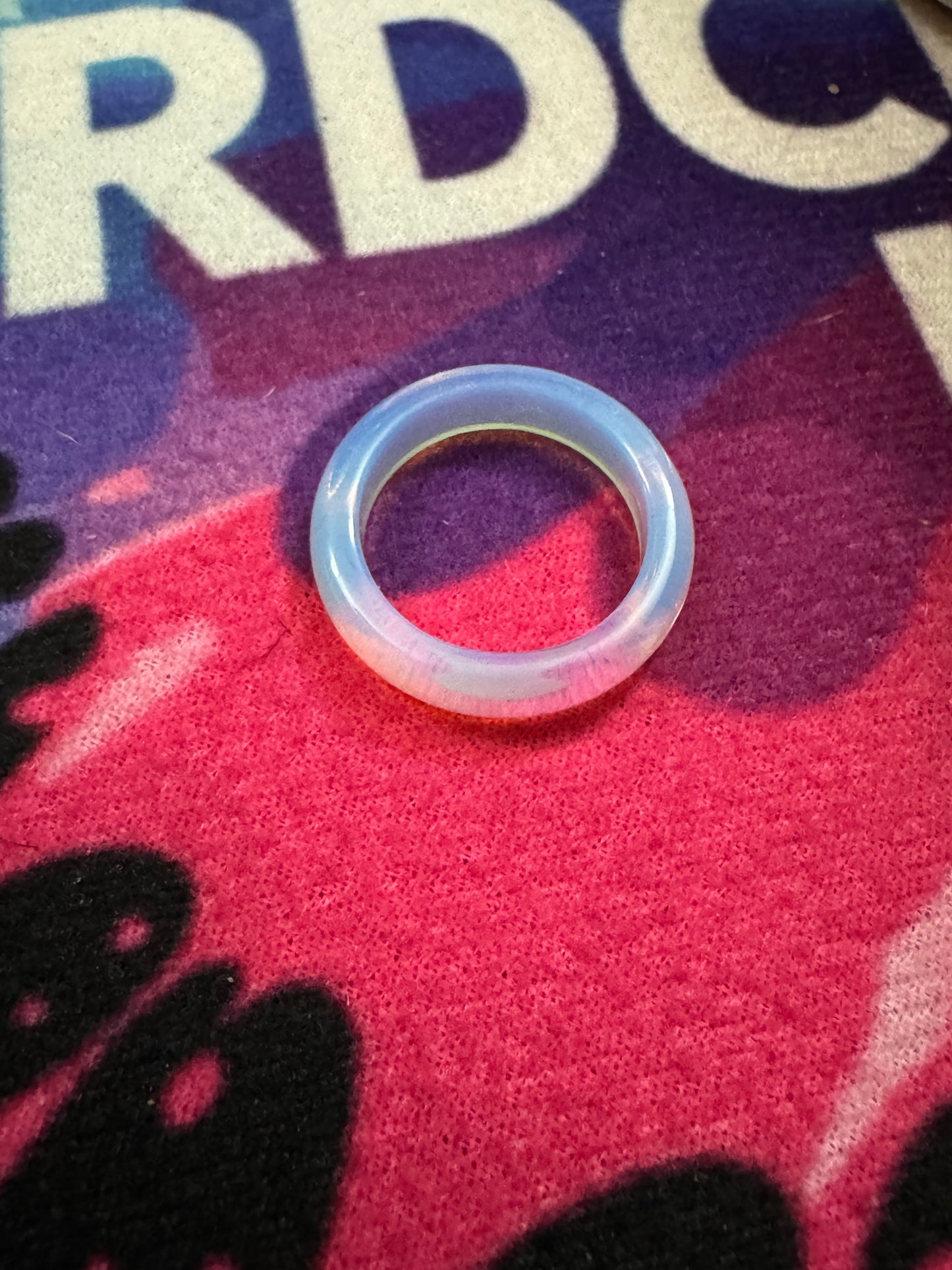 Opalite ring on a colorful fabric background