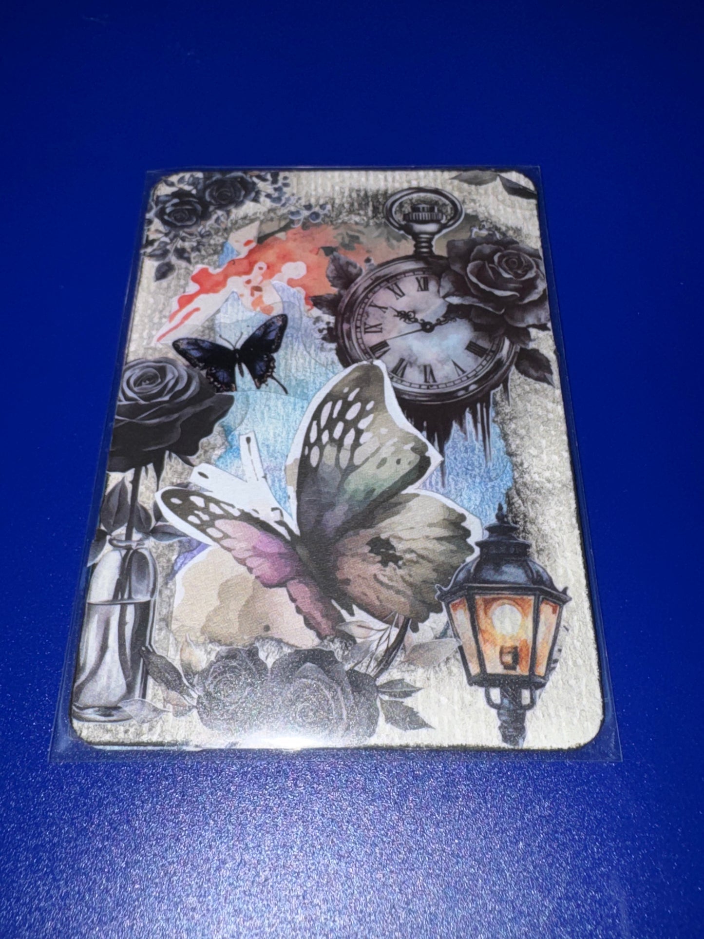 Decorative card with butterflies, clock, and lantern design on a blue background