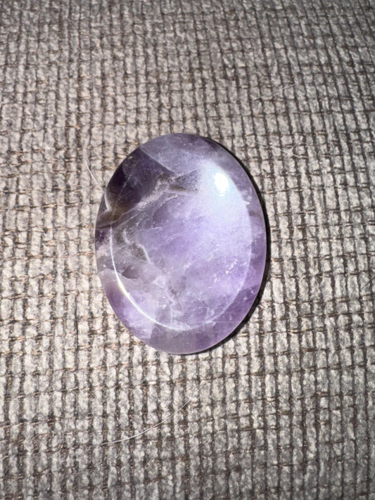 Purple stone on a textured fabric surface