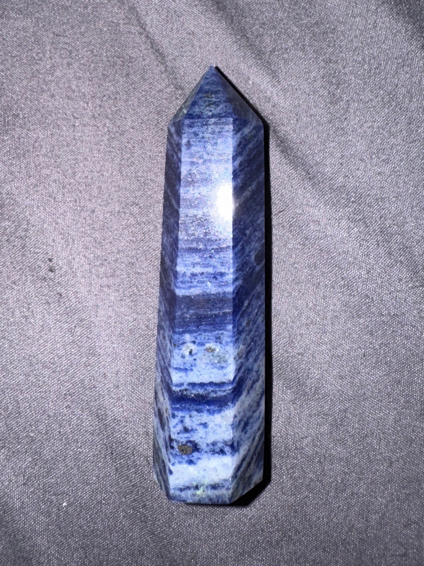 Blue crystal tower on a gray fabric background