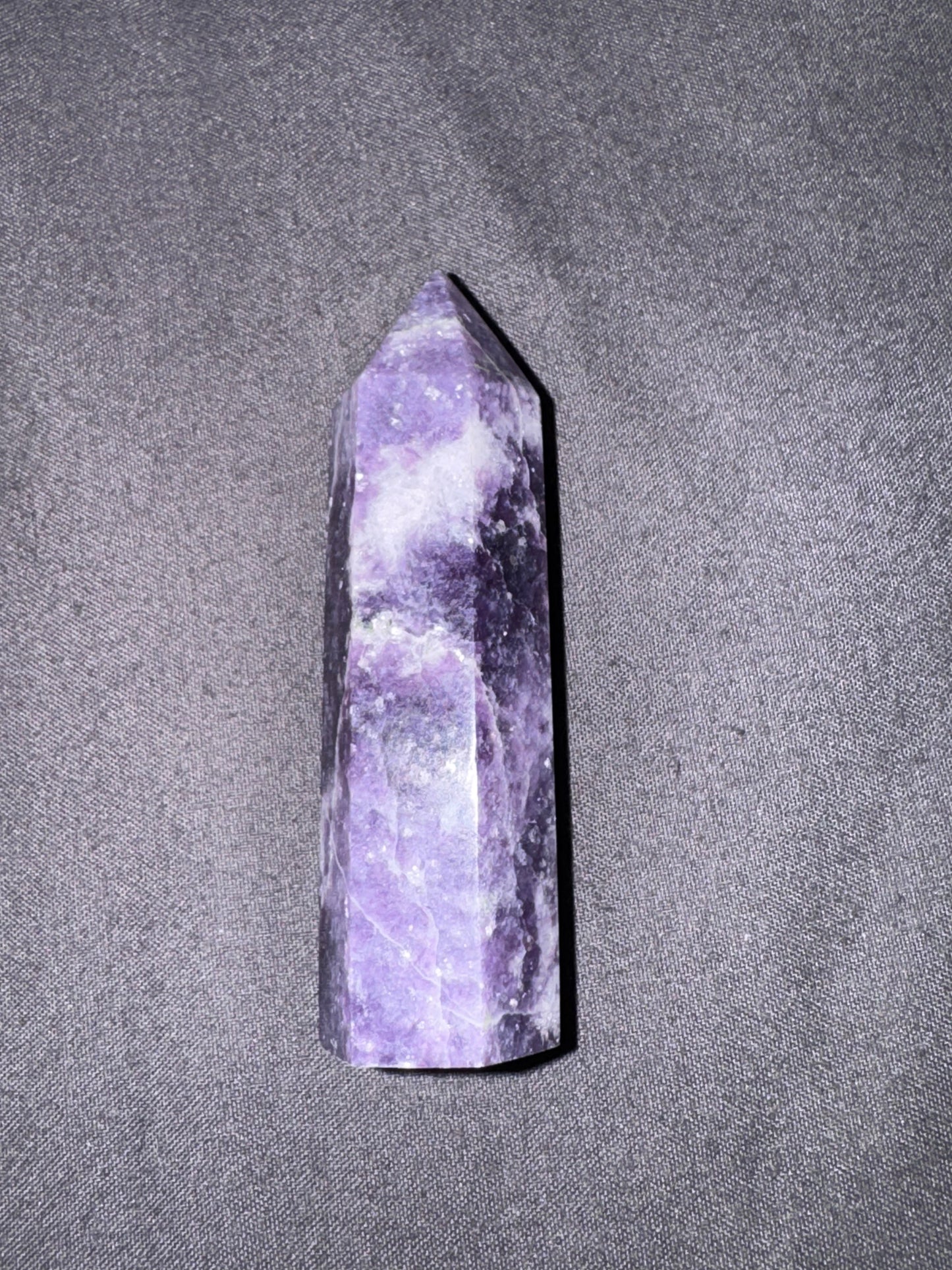 Purple crystal tower on a gray textured background