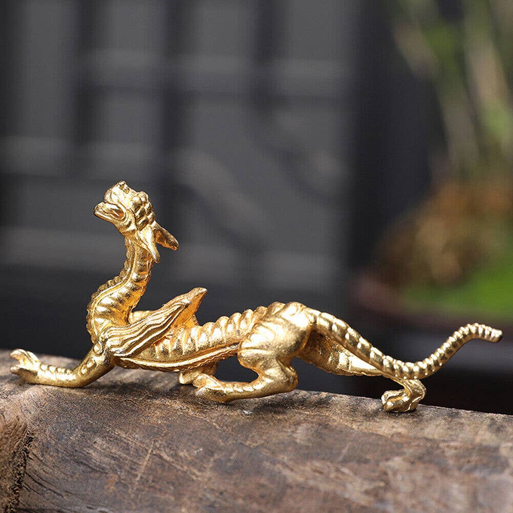 Gold dragon figurine on a wooden surface with a blurred background