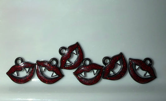Five red glitter lip-shaped charms with silver metal wire details and small hanging loops, arranged in a row on a light gray background.