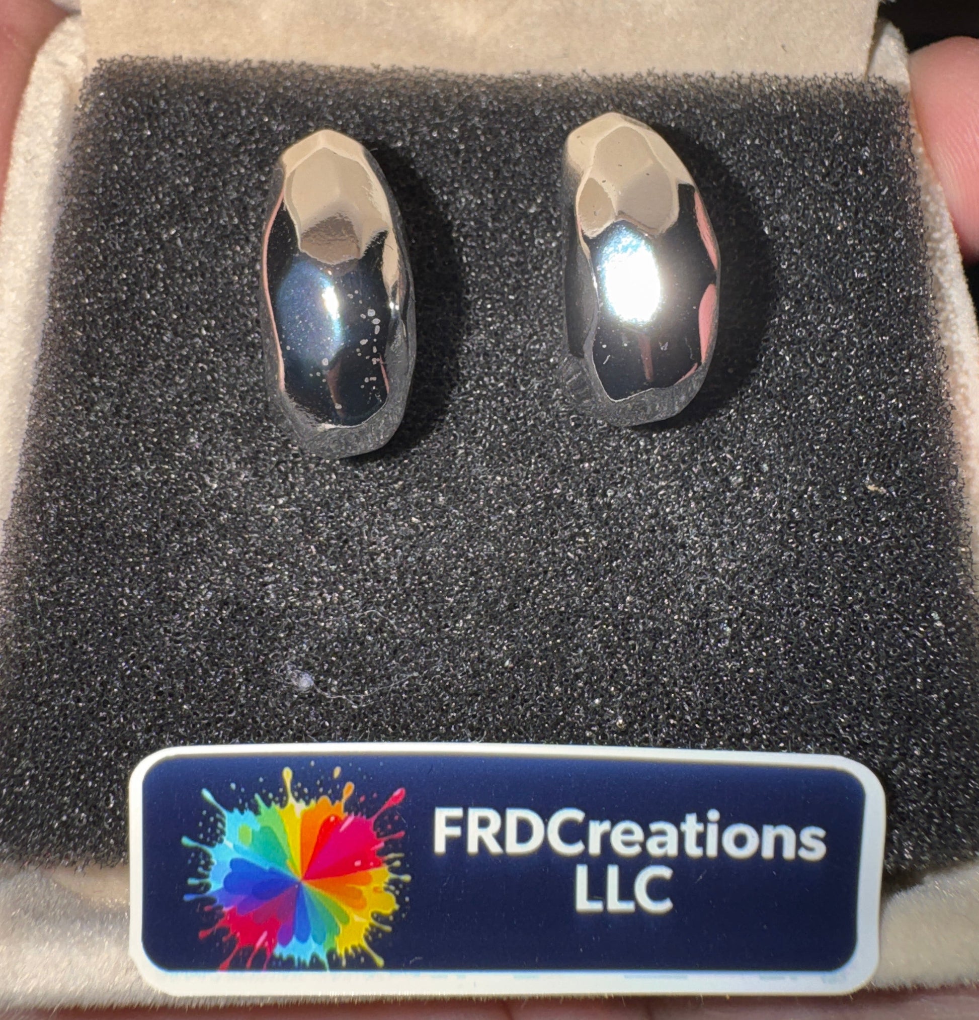 Two silver rings in a box with a FRD Creations LLC label.
