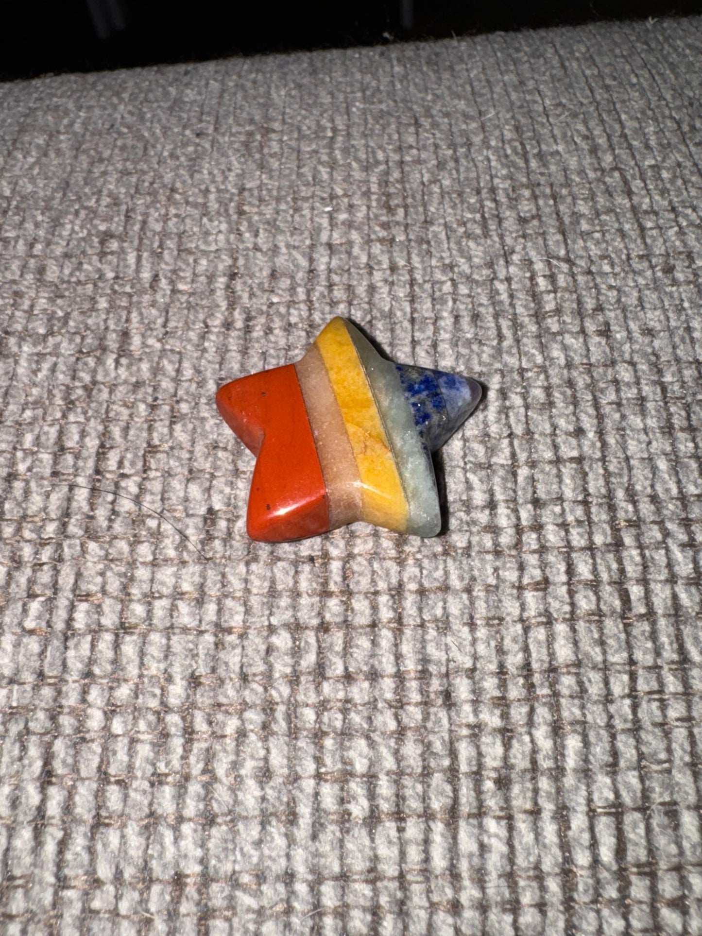 Rainbow star-shaped object on a textured surface