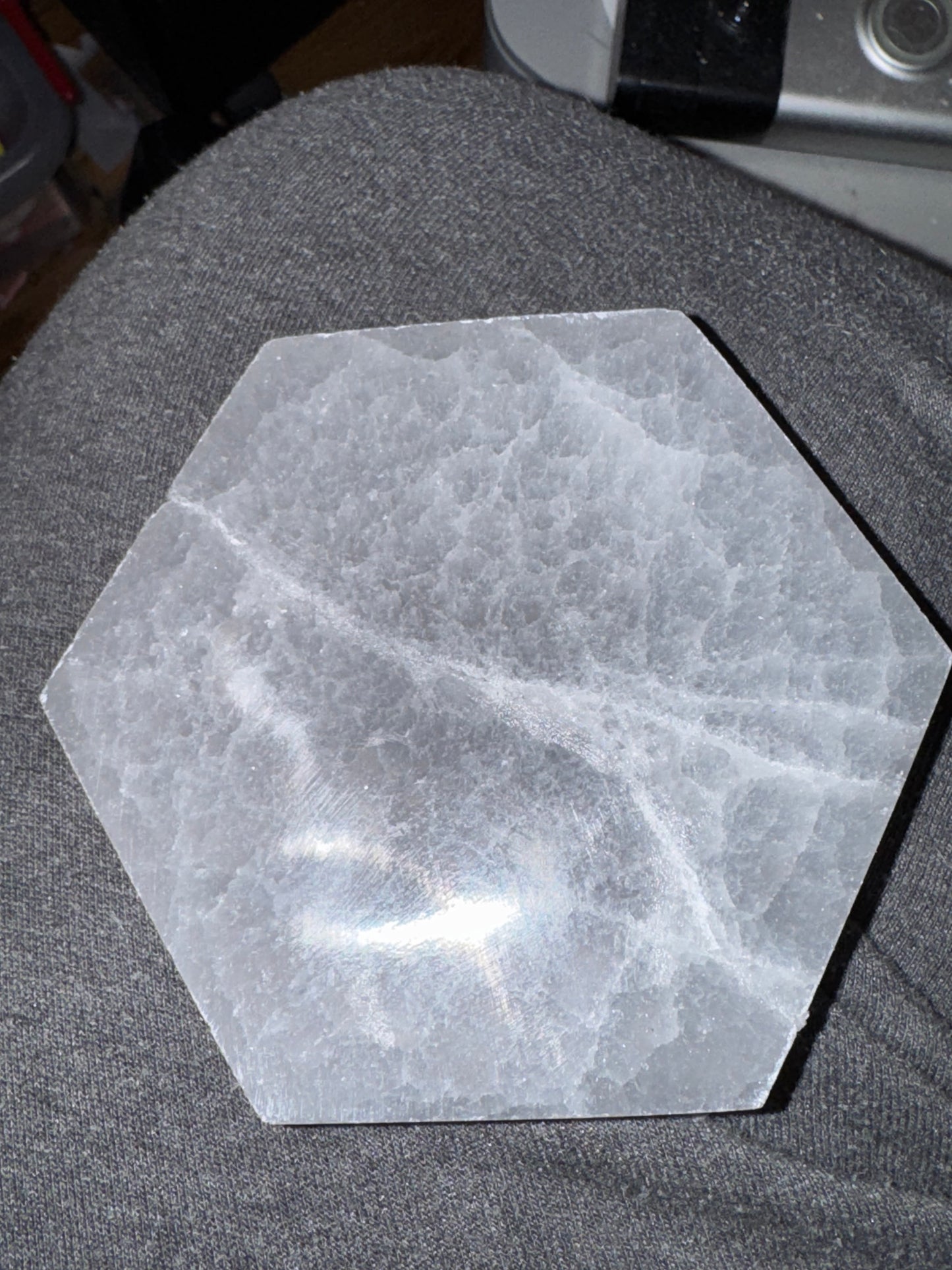 Hexagonal stone coaster on a gray surface