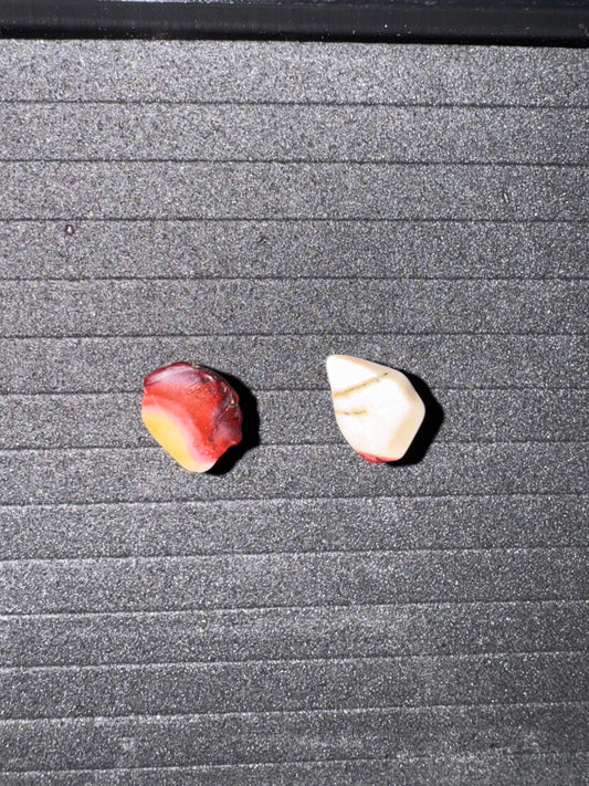 Two Mookite stone earrings on a textured gray surface