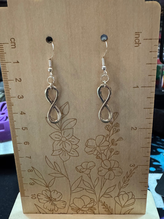 Silver infinity earrings on a floral-patterned card with measurements