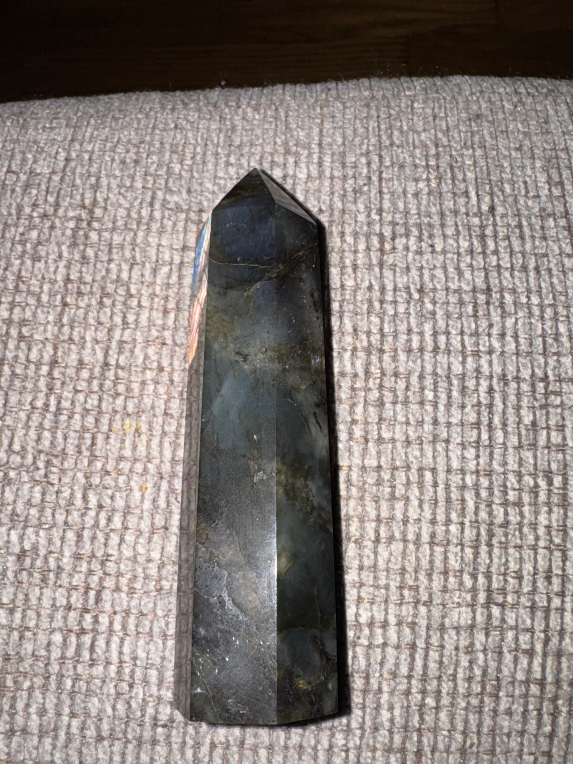 Black crystal pyramid on a textured surface
