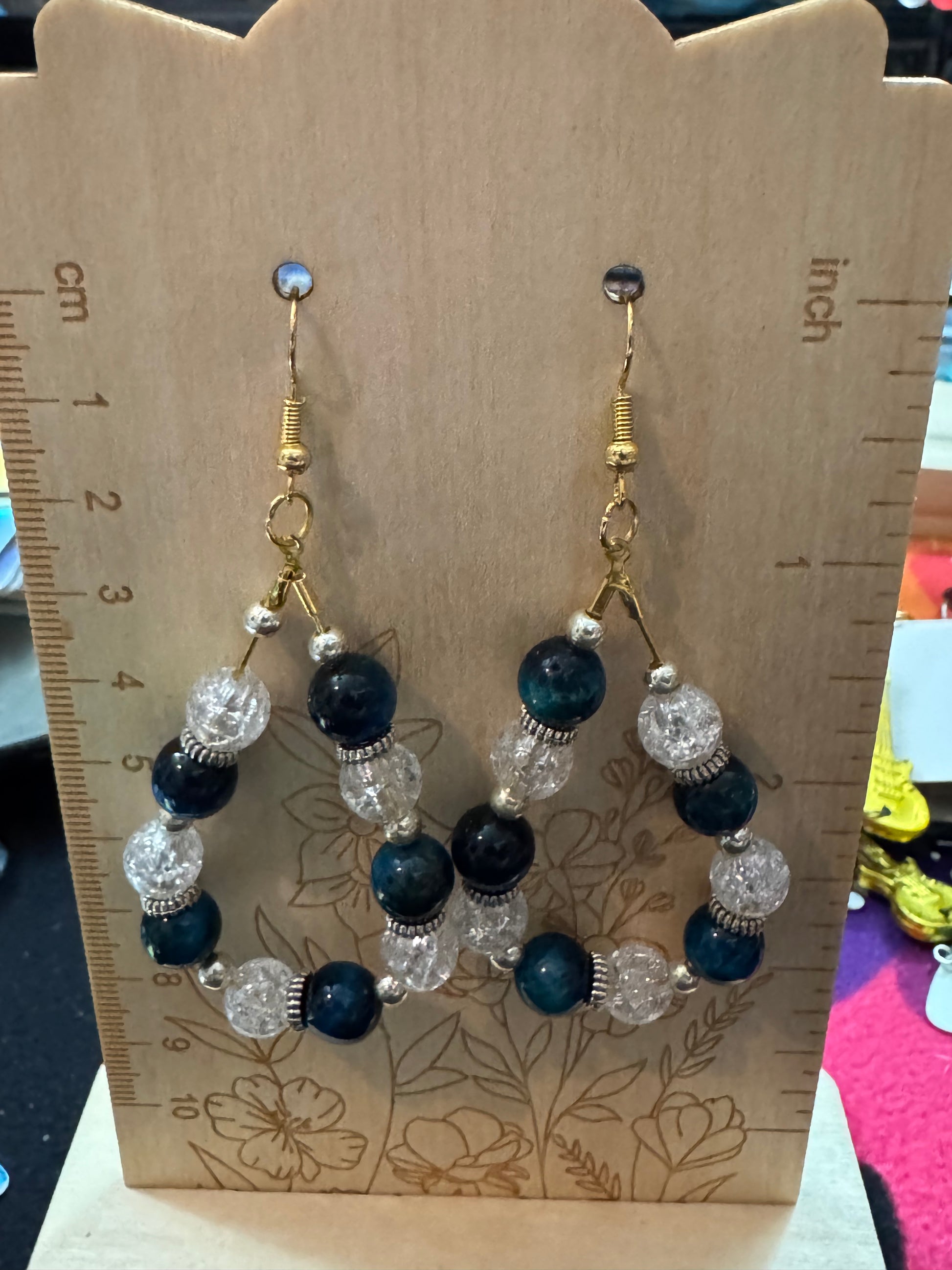 Beaded necklace on a wooden card with a ruler for scale