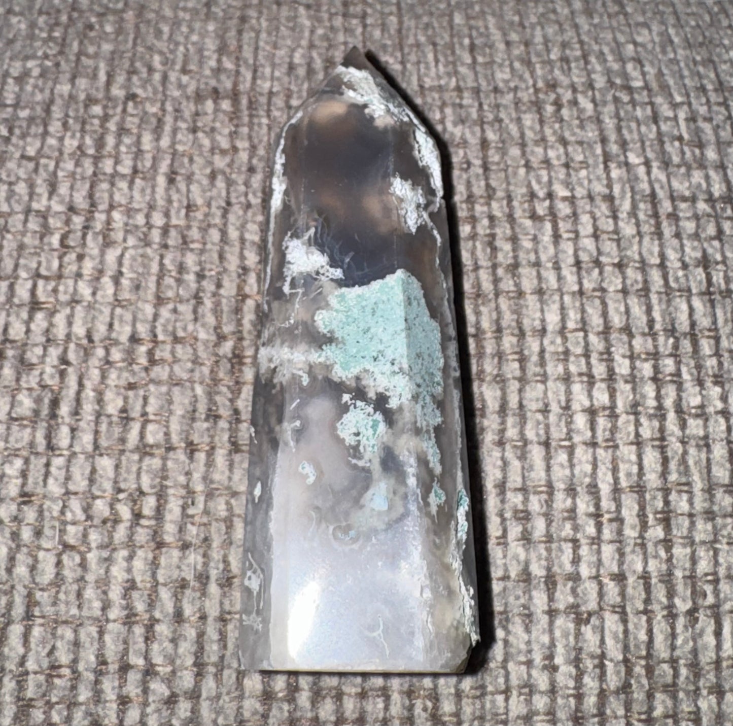 Crystal or mineral specimen on a textured surface