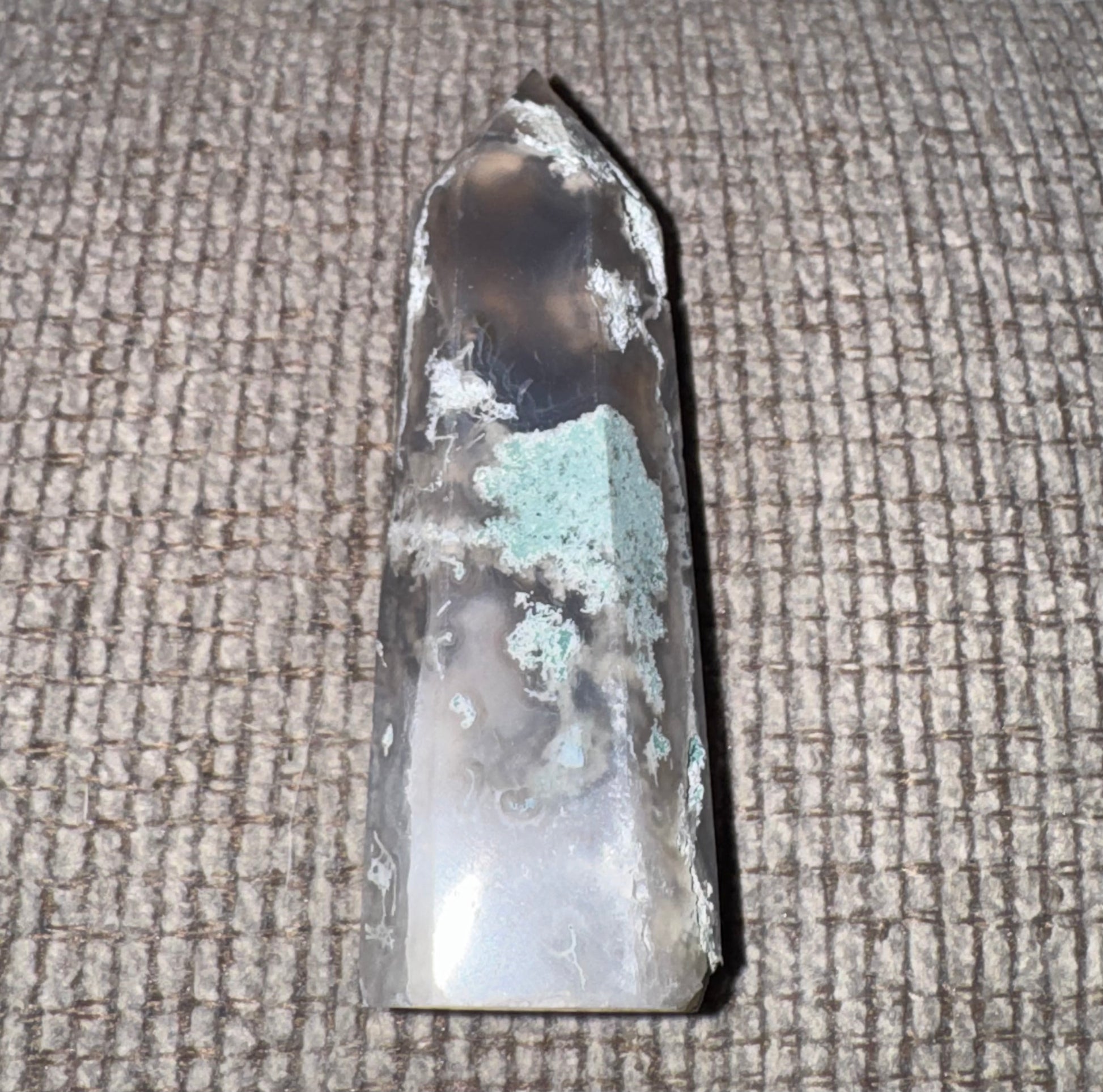 Crystal or mineral specimen on a textured surface