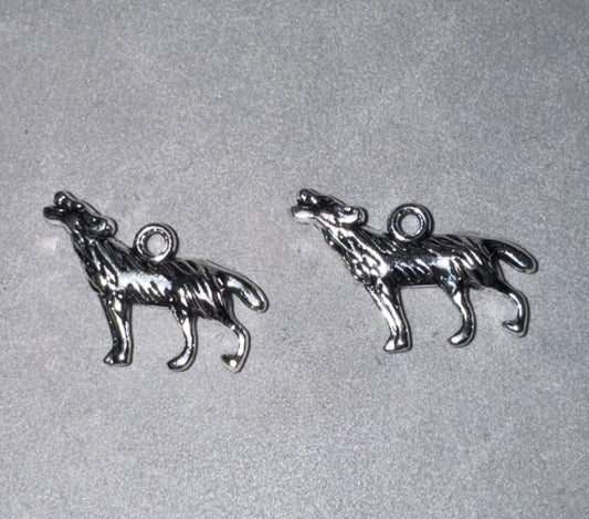 Two small silver-toned metal charms shaped like howling wolves, shown on a light gray textured background.