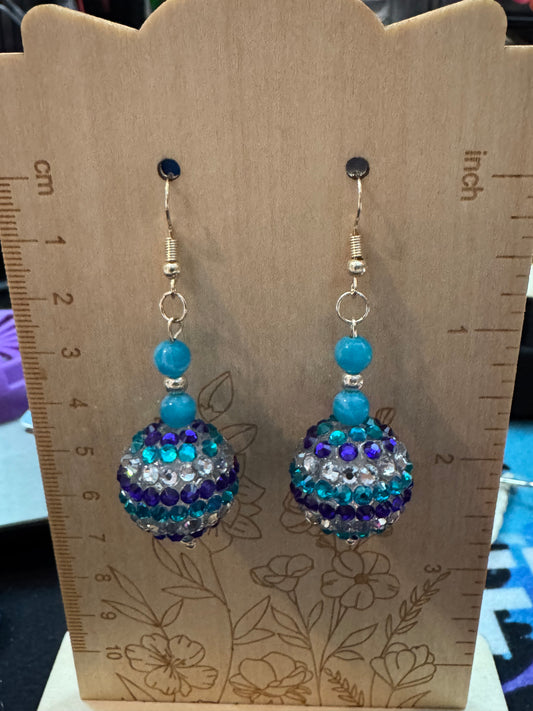 Pair of beaded earrings on a wooden display card with measurements.