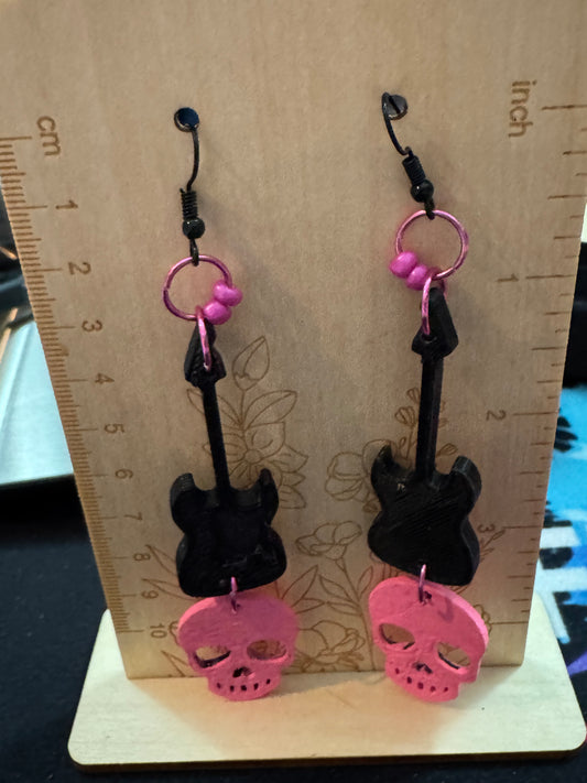 Black and pink earrings on a wooden board with a ruler for scale.