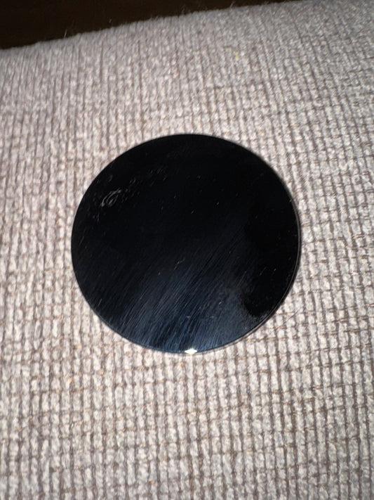 Black circular object on a textured gray surface
