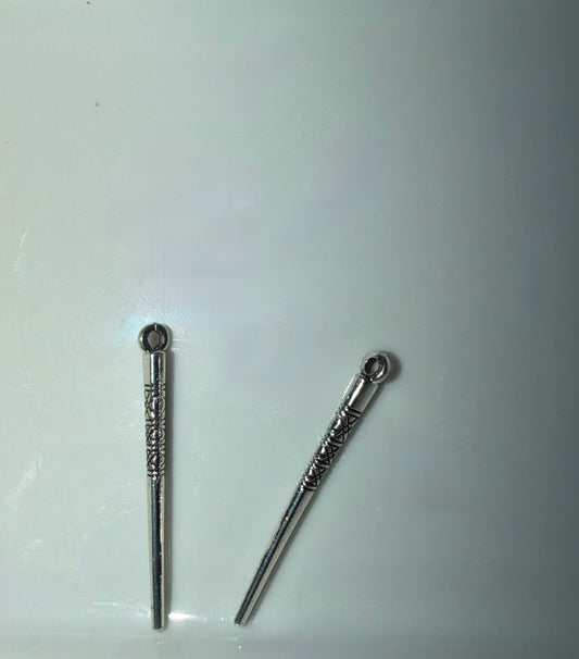 Two silver-toned metal charms with decorative engravings and loop tops, displayed on a plain light background.