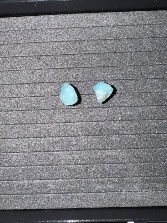 Two blue stones on a textured gray surface