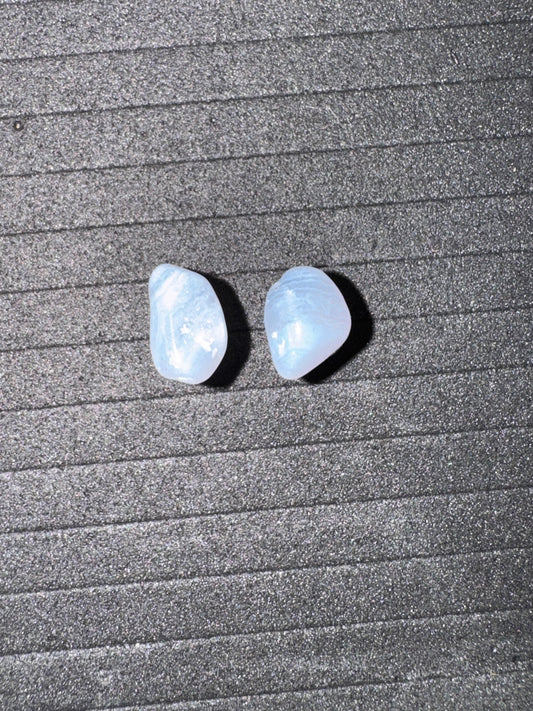 Two light blue stones on a textured gray surface