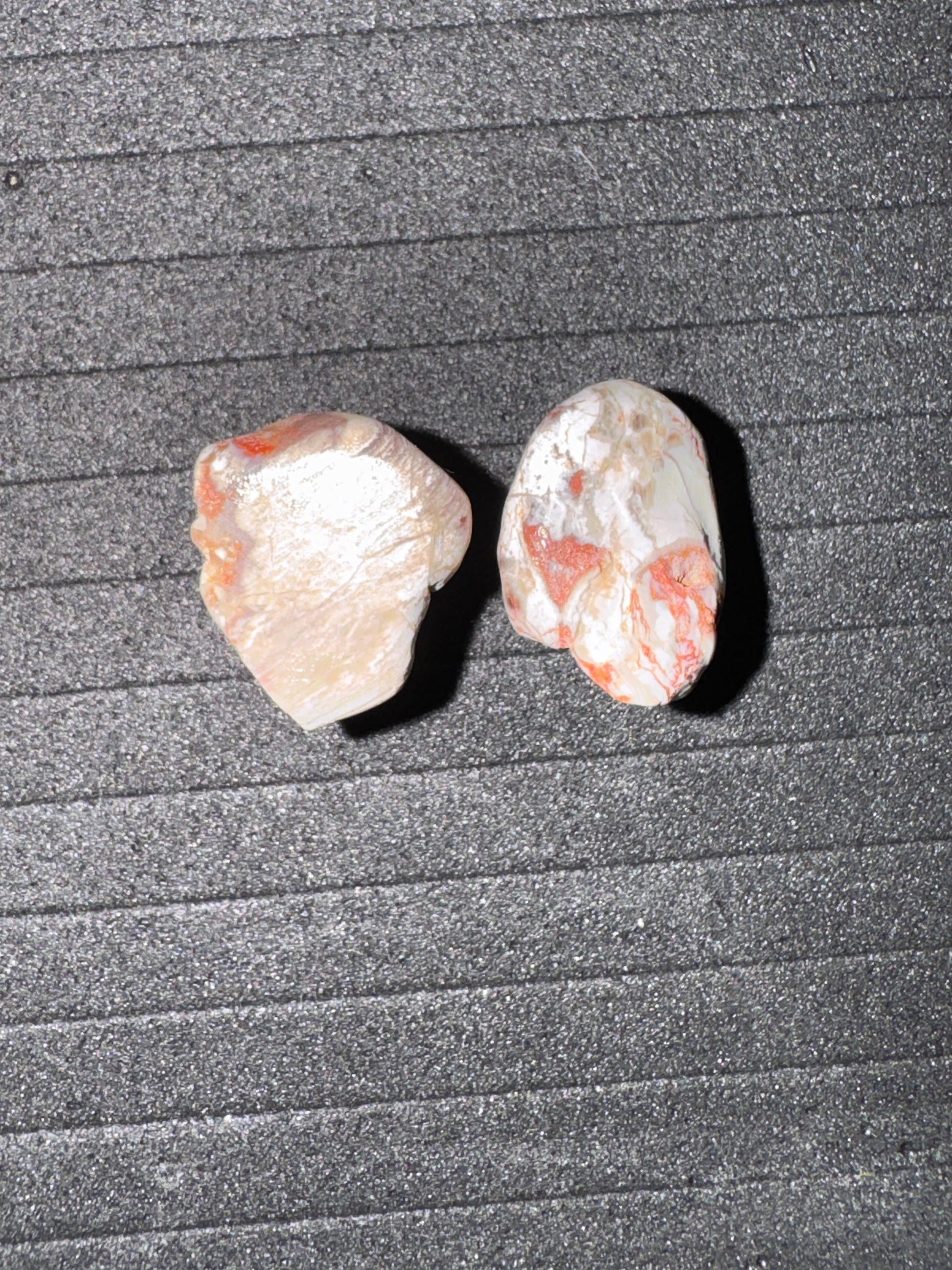 Two small stones on a textured gray surface