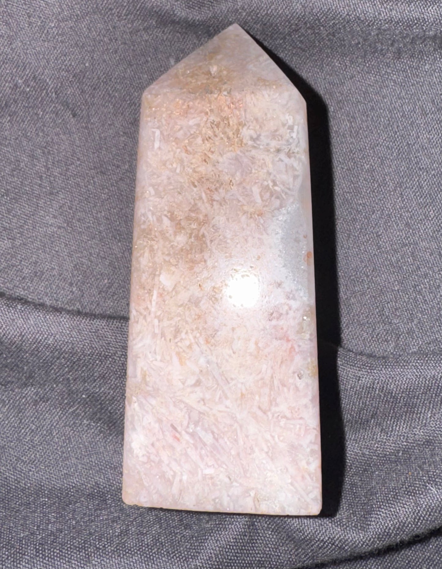 Crystal obelisk on a gray fabric background