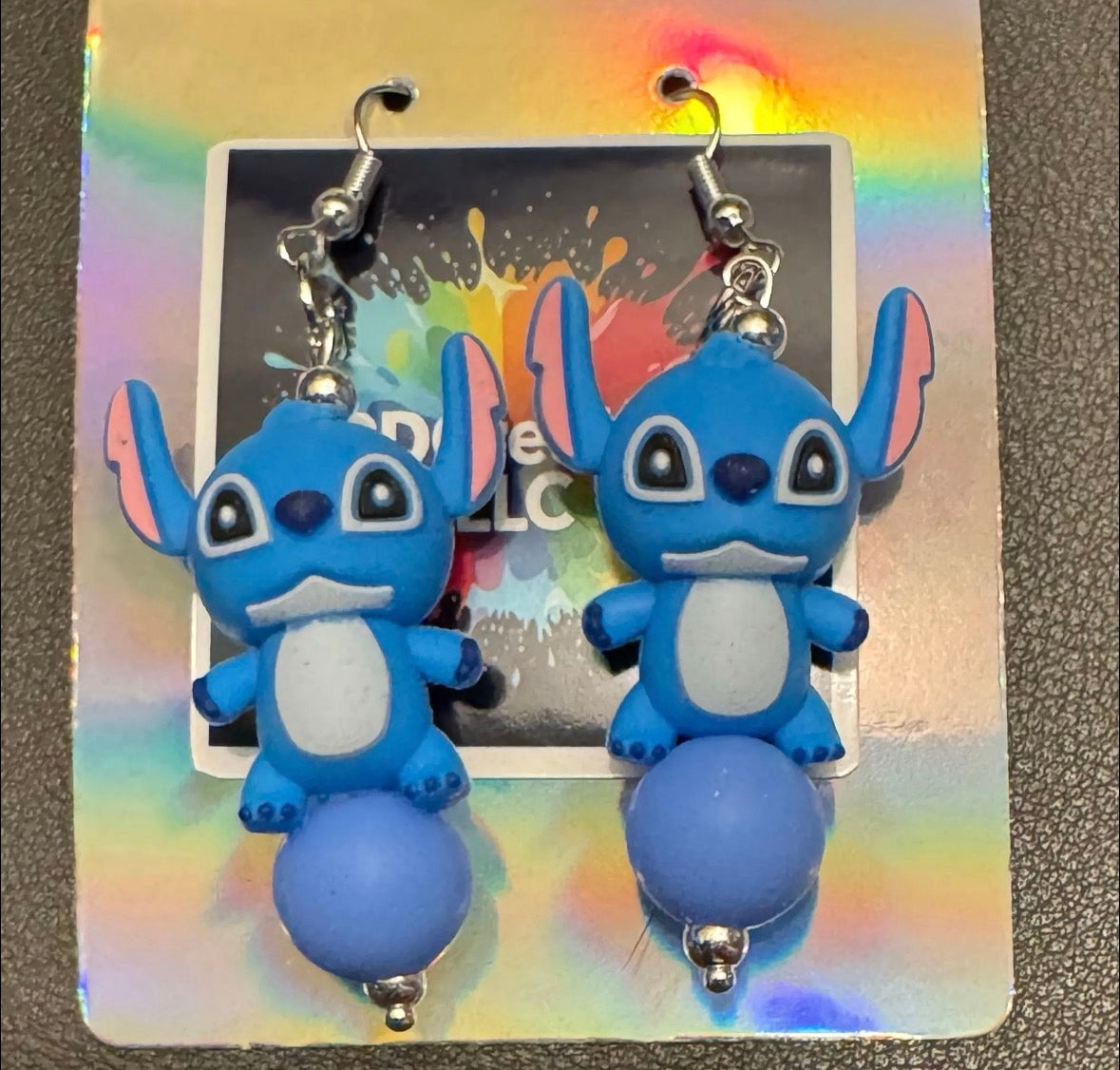 Blue cartoon character earrings on a colorful card