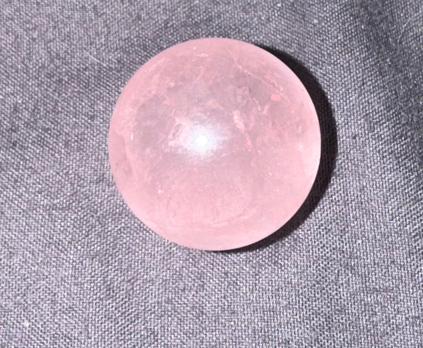 Pink stone on a gray fabric background
