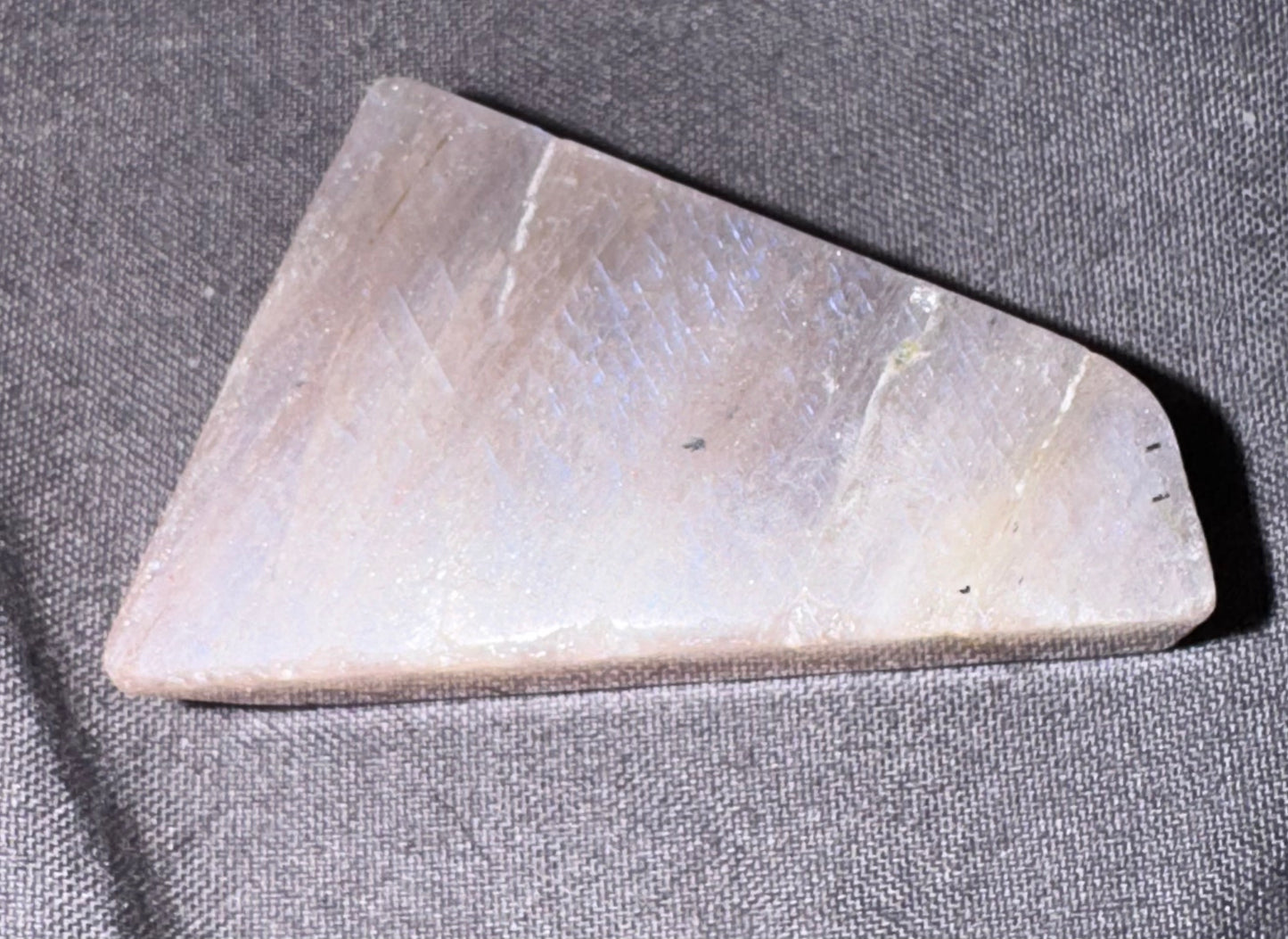 Triangular stone tool on a gray fabric background