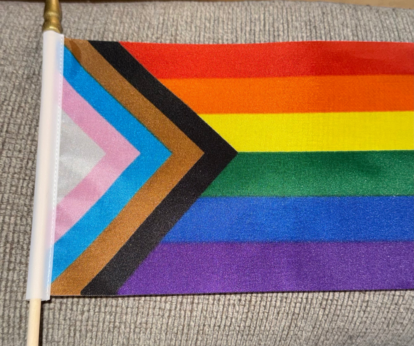 Flag with rainbow design and geometric shapes on a textured surface