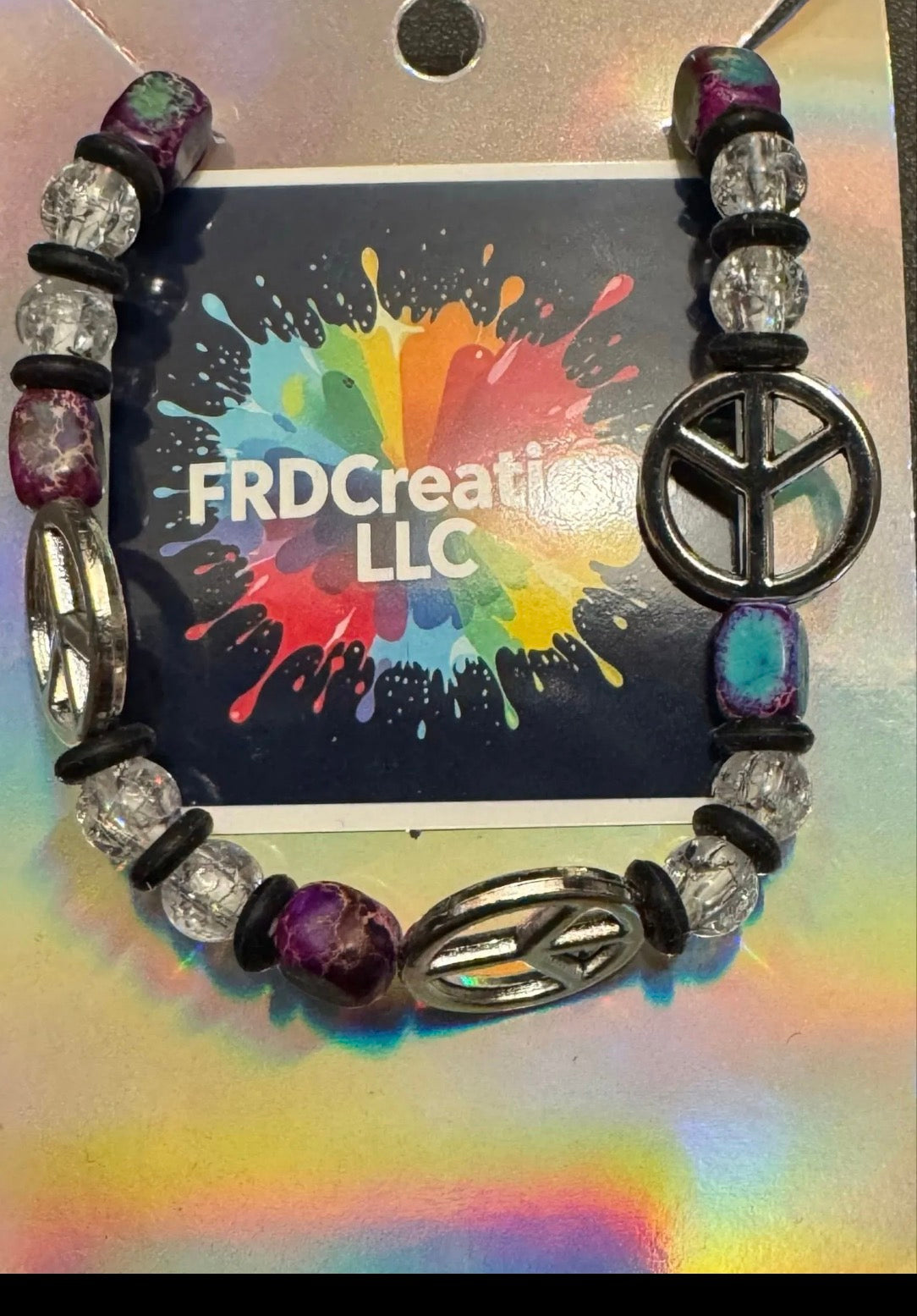 Bracelet with peace symbol bead on a colorful background 