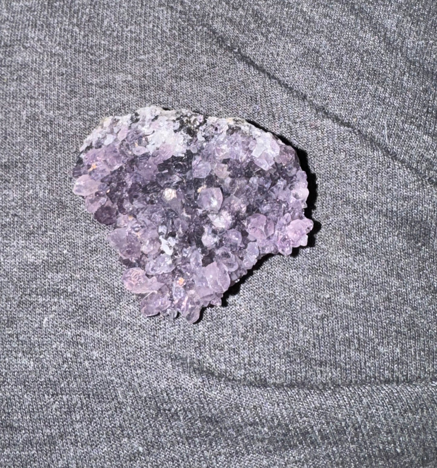 Purple crystal on a gray fabric background
