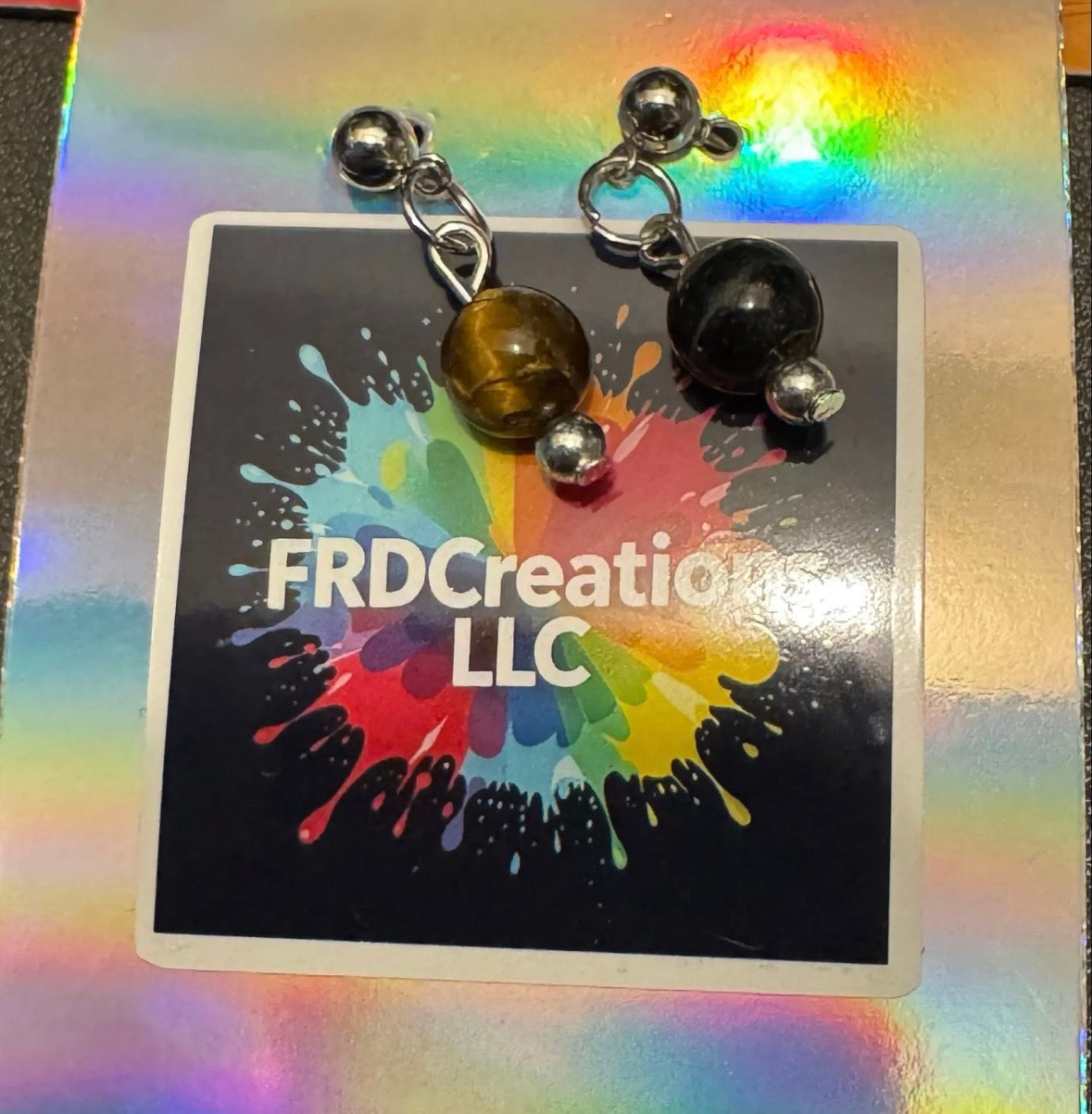 Earrings with yellow Tiger's eye beads on a card background