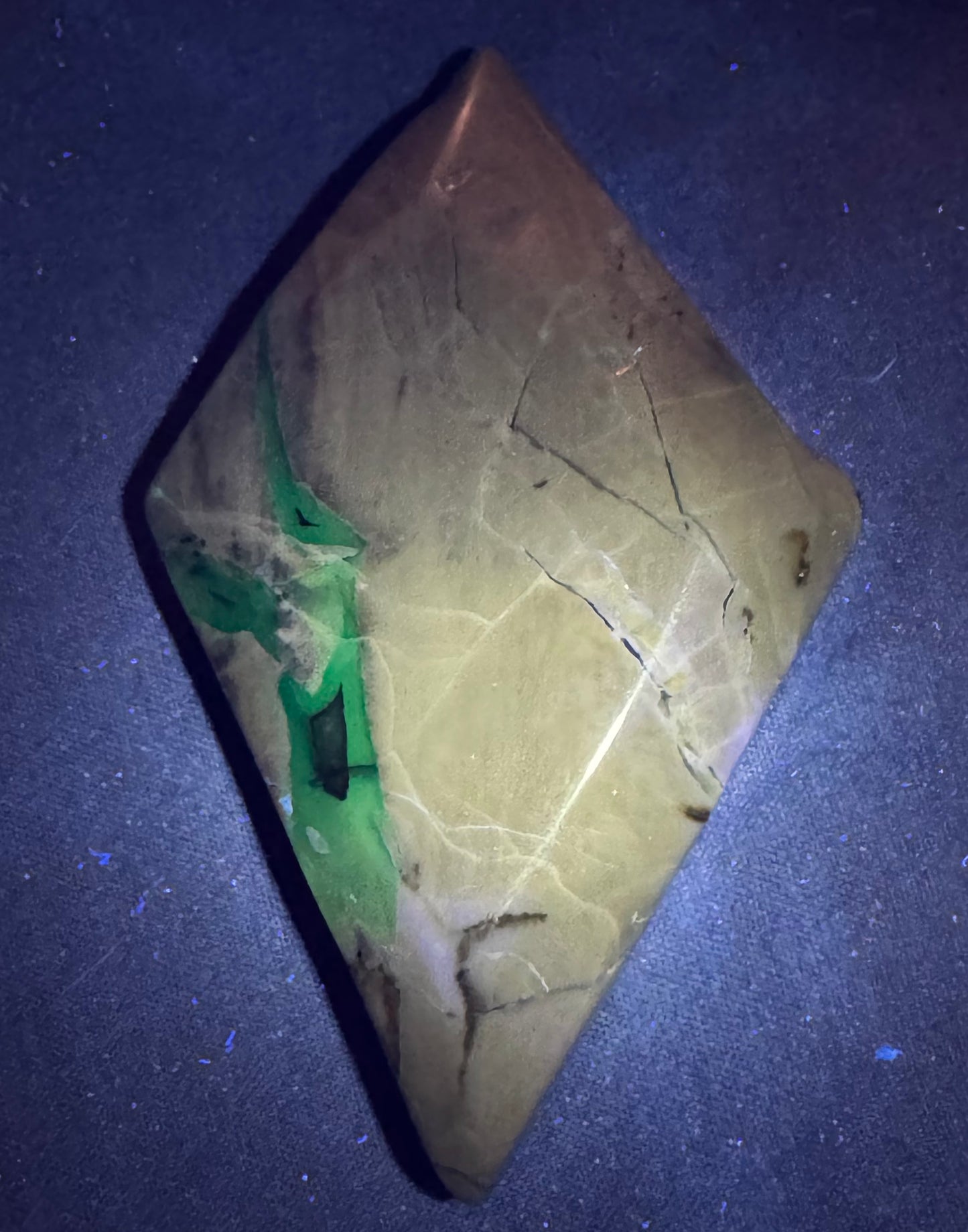 Geometric stone with green and beige patterns on a dark blue background