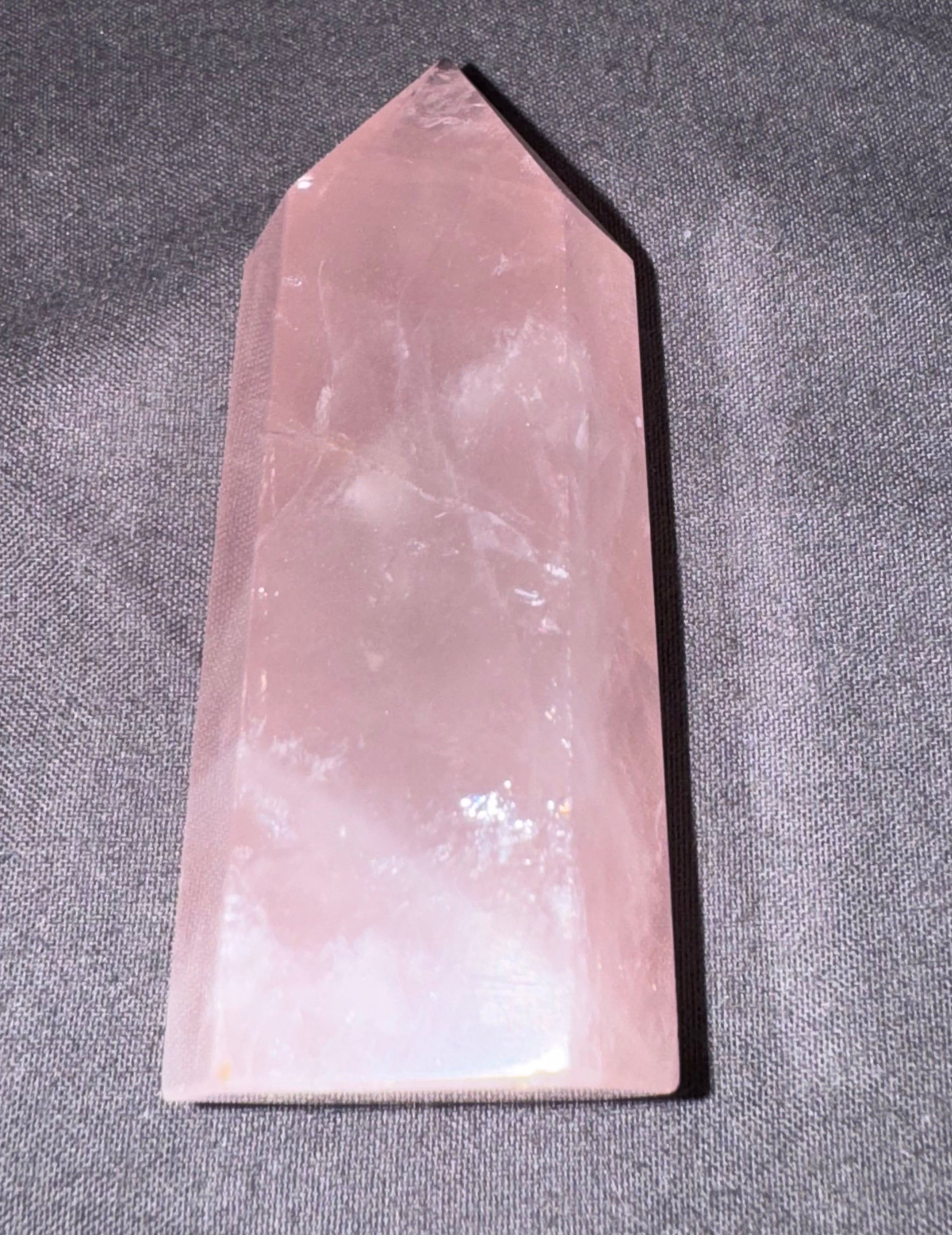 Rose quartz crystal on a gray fabric background