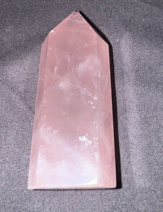 Rose quartz crystal on a gray fabric background