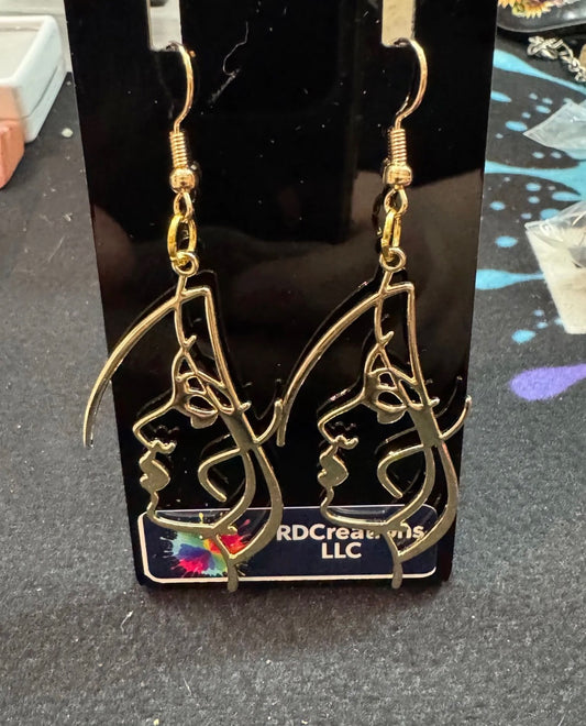 Gold color female face earrings .