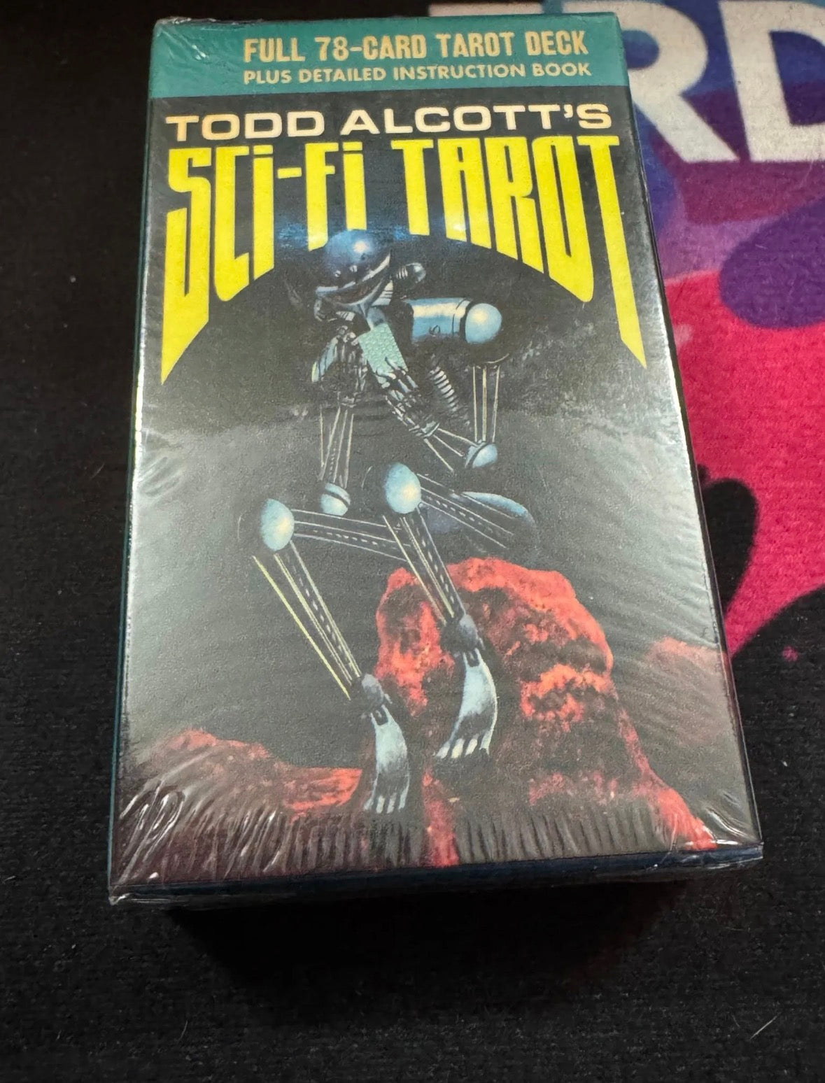 Packaged sci-fi tarot deck with robot illustration on a dark surface