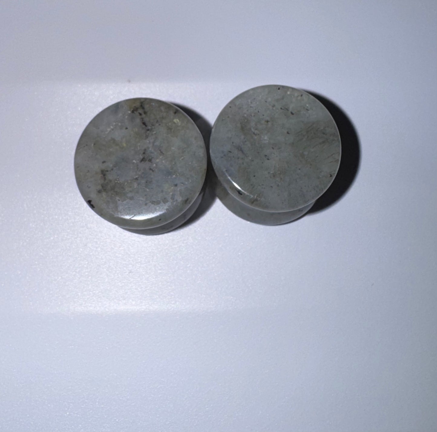 Two labradorite ear gauges on a white background